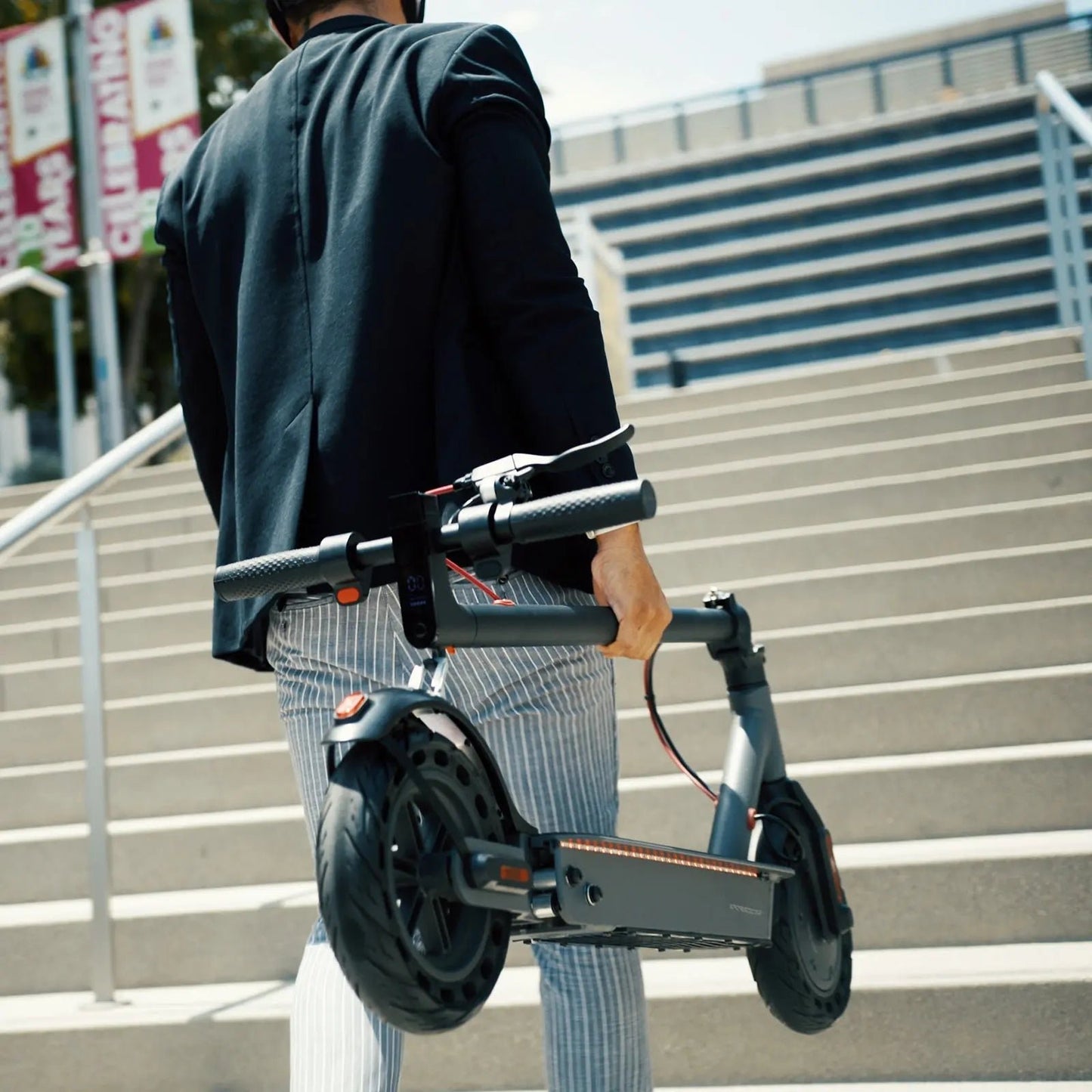 Person holding a scooter on outdoor steps