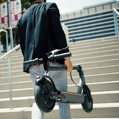 Person holding a scooter on outdoor steps